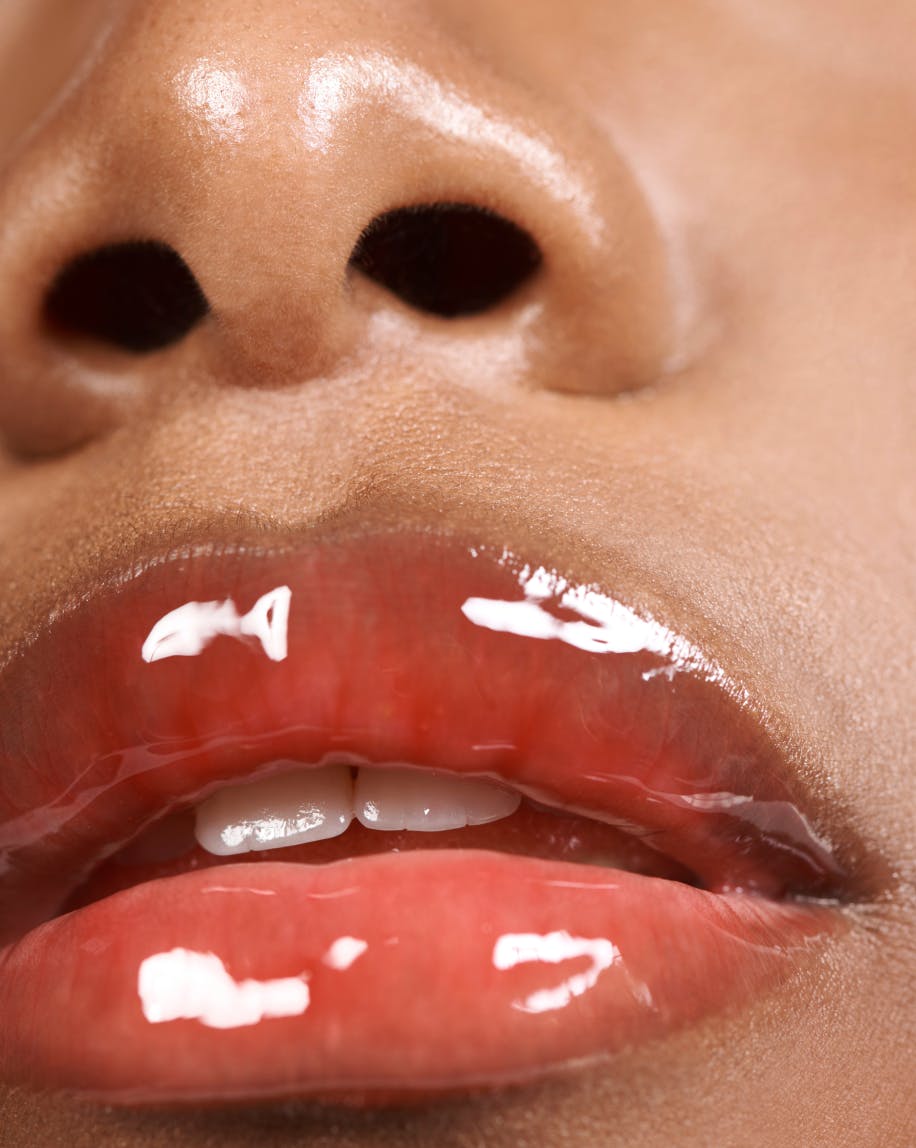 up close shot of model wearing lip gloss in red